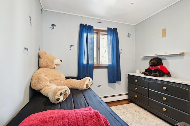 bedroom with a baseboard heating unit, wood finished floors, and ornamental molding