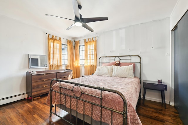 bedroom featuring dark wood finished floors, baseboard heating, ceiling fan, and baseboards