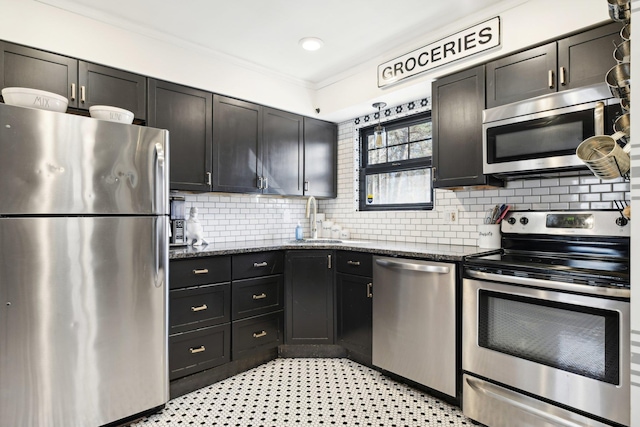 kitchen with a sink, dark stone countertops, backsplash, appliances with stainless steel finishes, and crown molding