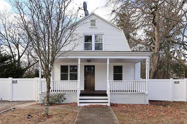 dutch colonial with a gate, covered porch, a gambrel roof, and fence