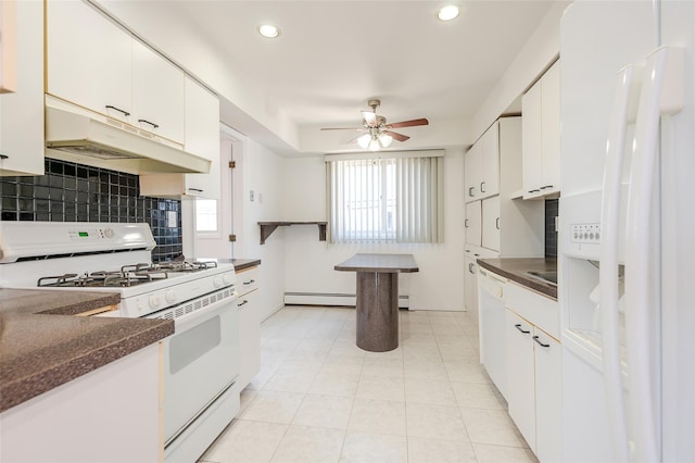 kitchen with under cabinet range hood, baseboard heating, white appliances, and dark countertops