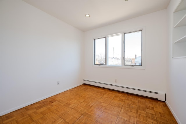 empty room with recessed lighting, a baseboard heating unit, and baseboards