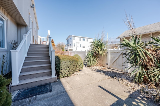 view of patio featuring stairway, fence, and a gate