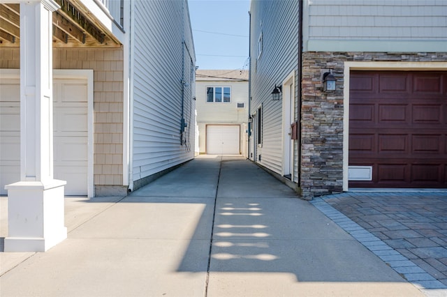 view of property exterior with stone siding and a garage