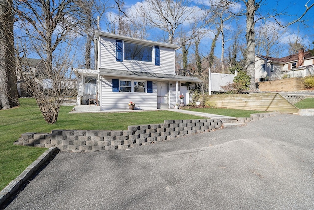 traditional-style house with a front yard and fence