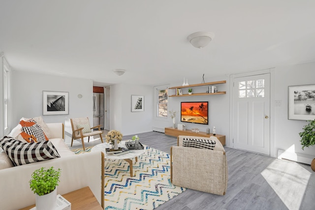 living room with baseboard heating and wood finished floors