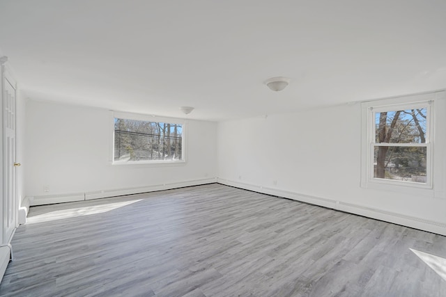 unfurnished room with a baseboard radiator and wood finished floors