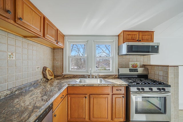 kitchen with a sink, tasteful backsplash, appliances with stainless steel finishes, and brown cabinetry