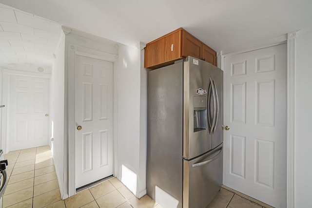 kitchen featuring light tile patterned flooring, brown cabinets, and stainless steel fridge with ice dispenser