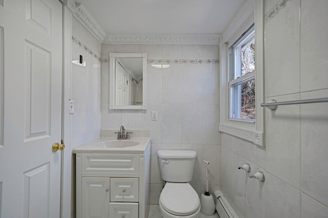 bathroom with a baseboard radiator, toilet, tile walls, and vanity