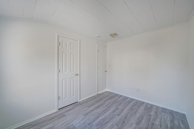 empty room featuring wood finished floors and baseboards