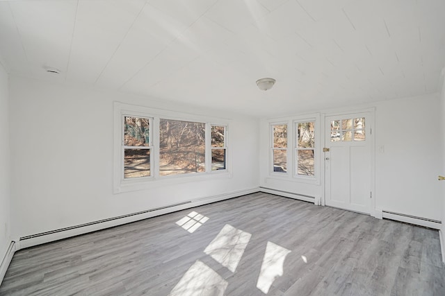 empty room with a baseboard radiator, a baseboard heating unit, and wood finished floors