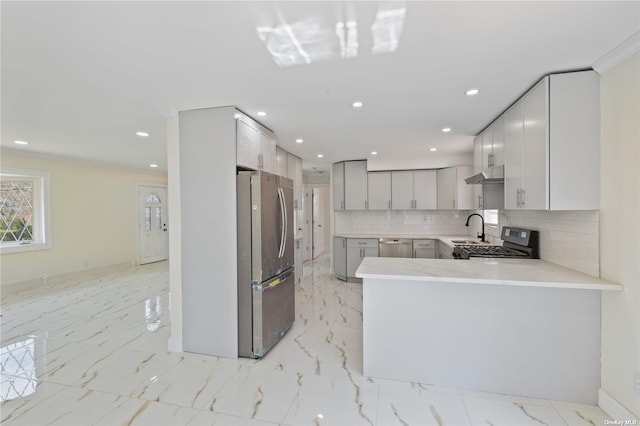 kitchen with marble finish floor, under cabinet range hood, stainless steel appliances, light countertops, and decorative backsplash