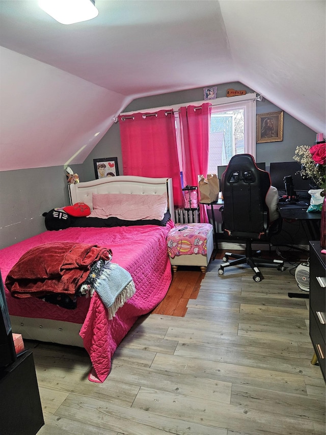 bedroom featuring lofted ceiling and wood finished floors