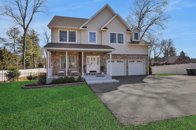 view of front facade featuring fence, a porch, a garage, stone siding, and driveway