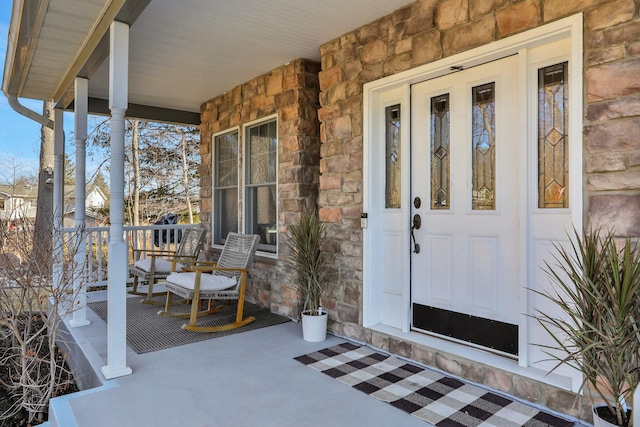 entrance to property featuring stone siding and covered porch