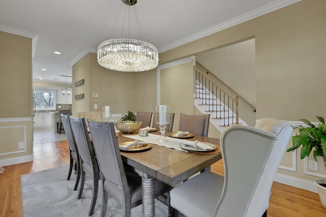 dining space featuring an inviting chandelier, light wood-style flooring, stairway, and ornamental molding