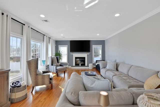 living room featuring recessed lighting, visible vents, light wood-style flooring, and ornamental molding