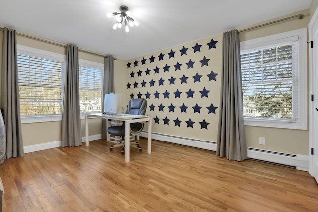 home office featuring a wealth of natural light, light wood-style flooring, a baseboard heating unit, and baseboards