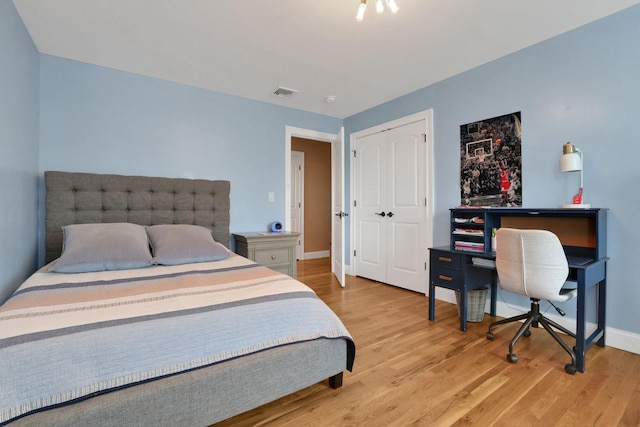 bedroom featuring visible vents, baseboards, a closet, and light wood-style flooring