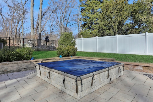 view of pool featuring a patio area, a lawn, and a fenced backyard