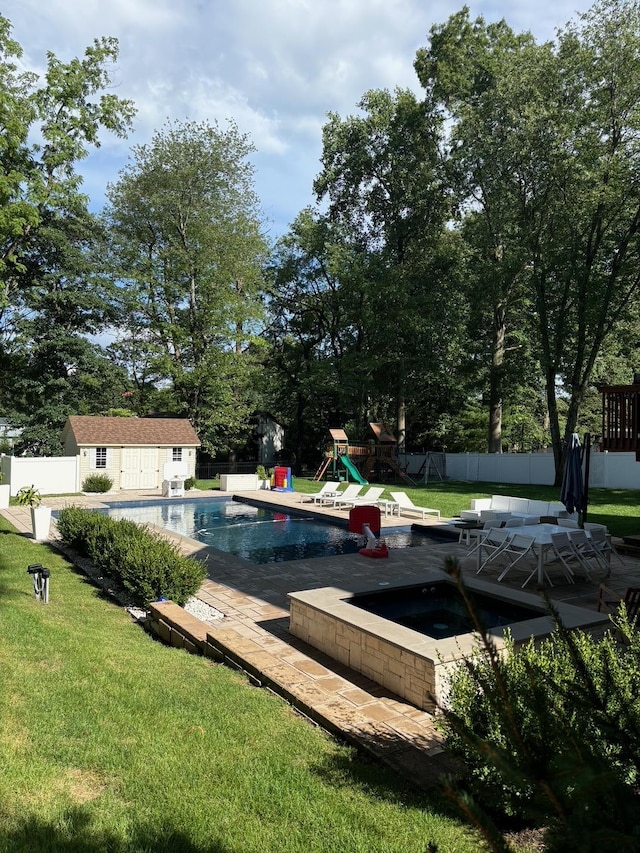 pool with a yard, a fenced backyard, a hot tub, an outdoor structure, and a playground