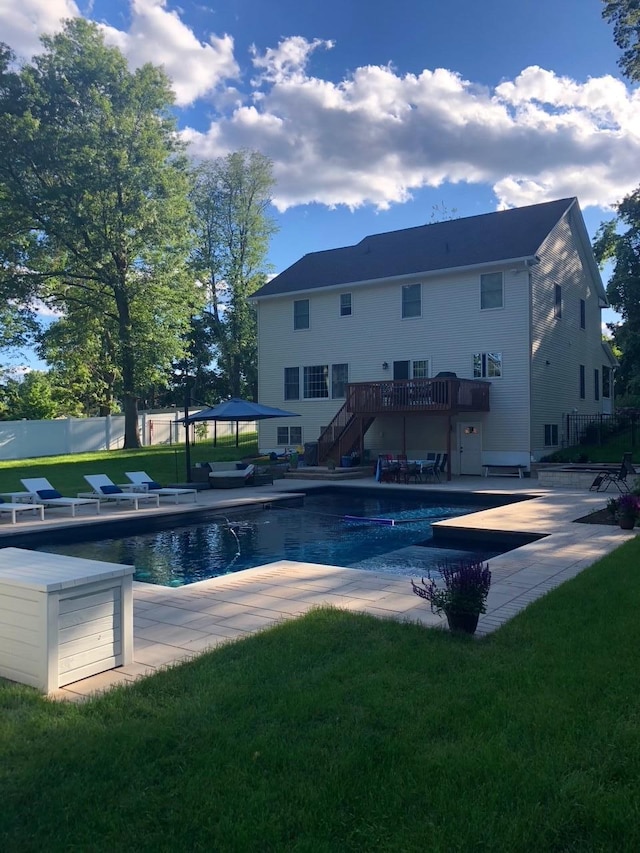 pool with fence, stairs, a deck, a yard, and a patio area