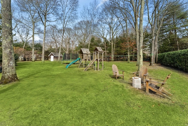 view of play area featuring an outbuilding, a trampoline, and a lawn