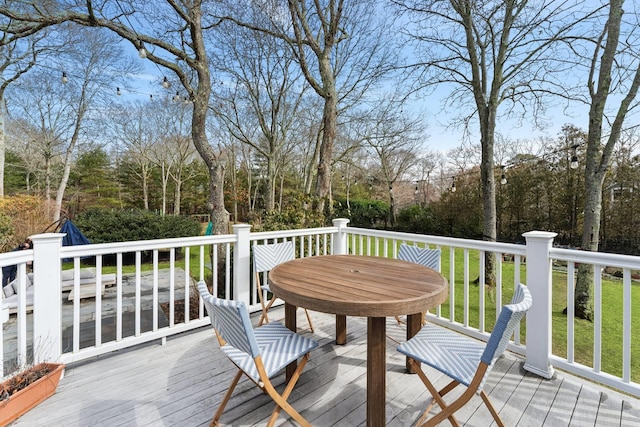 wooden terrace with a yard and outdoor dining space