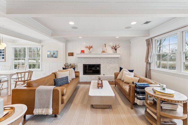 living room featuring visible vents, beam ceiling, plenty of natural light, and a fireplace