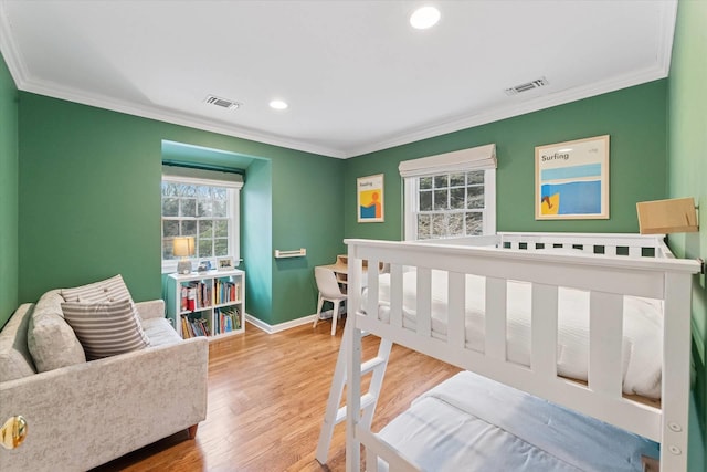 bedroom featuring crown molding, wood finished floors, baseboards, and visible vents