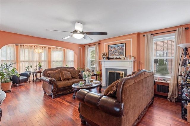 living room with plenty of natural light, ceiling fan, a fireplace, and hardwood / wood-style flooring