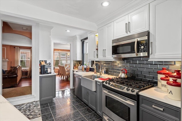 kitchen featuring a sink, stainless steel appliances, white cabinets, and light countertops