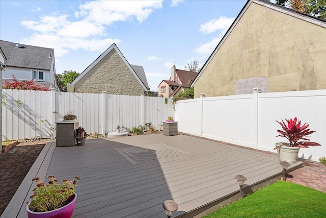 wooden terrace with a fenced backyard