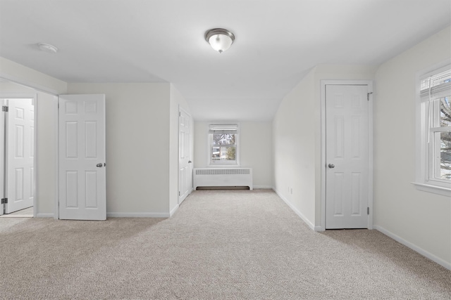 unfurnished bedroom featuring radiator, baseboards, and carpet floors