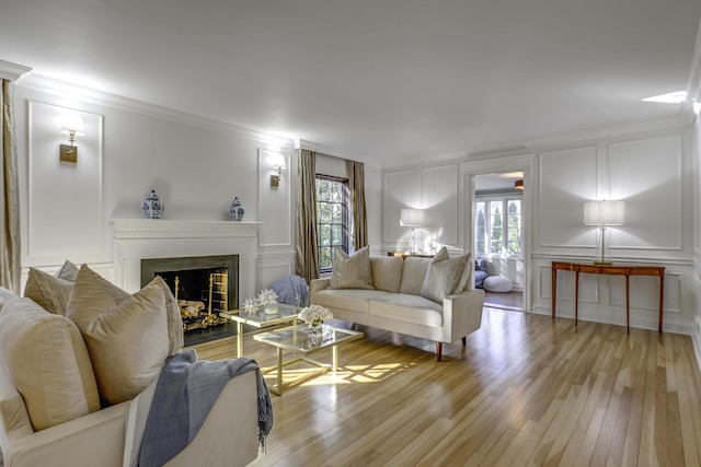 living room featuring a decorative wall, a healthy amount of sunlight, and crown molding