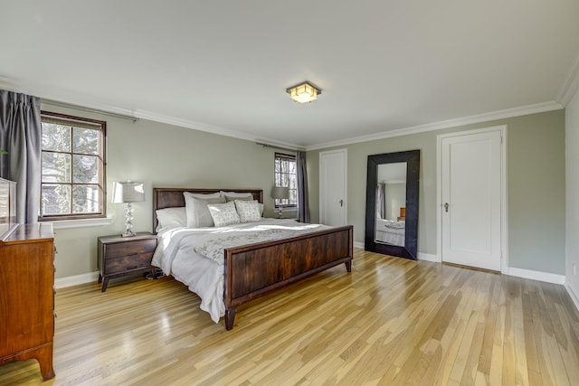 bedroom with crown molding, light wood-type flooring, and baseboards