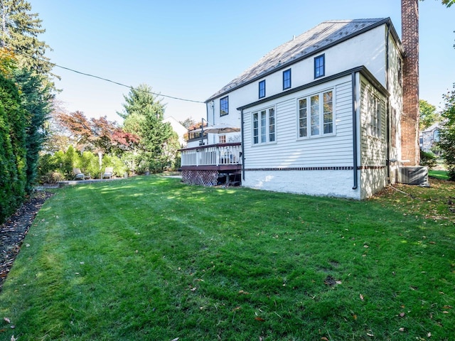 back of house featuring a wooden deck, cooling unit, a chimney, and a yard