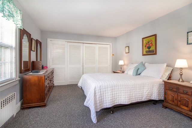 carpeted bedroom featuring radiator and a closet