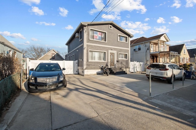 view of front of home with a gate, stucco siding, and fence