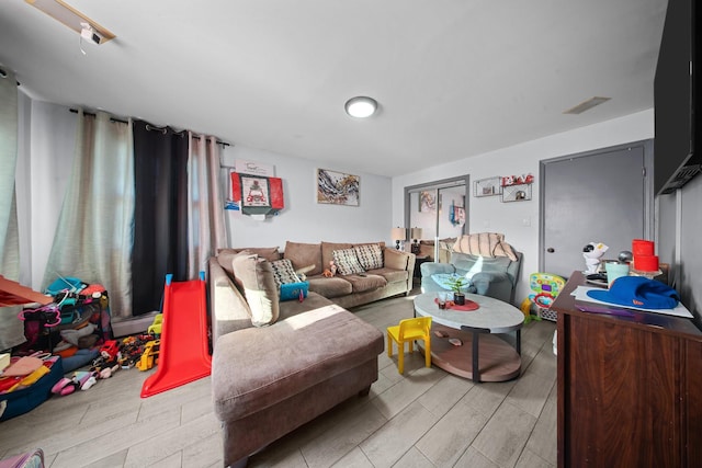 living area featuring wood finish floors and visible vents