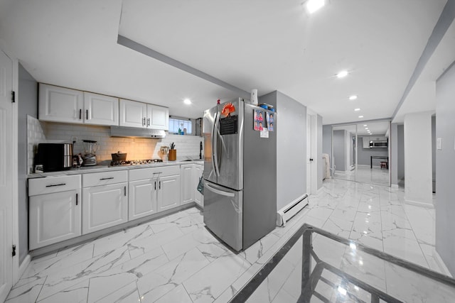 kitchen featuring under cabinet range hood, baseboard heating, white cabinets, marble finish floor, and stainless steel appliances