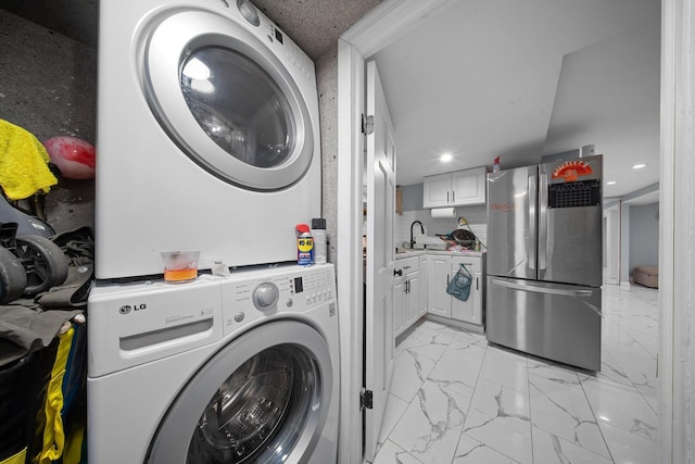 laundry area with laundry area, recessed lighting, a sink, stacked washer and clothes dryer, and marble finish floor