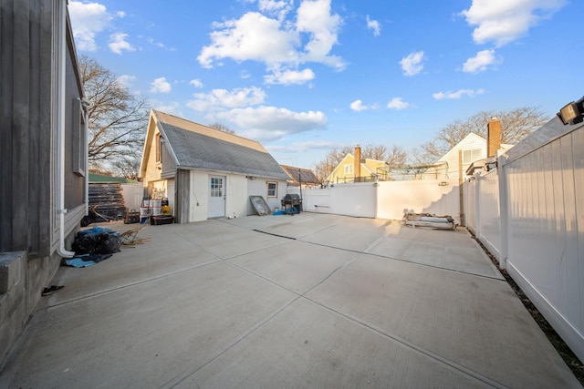 view of patio with an outbuilding and a fenced backyard