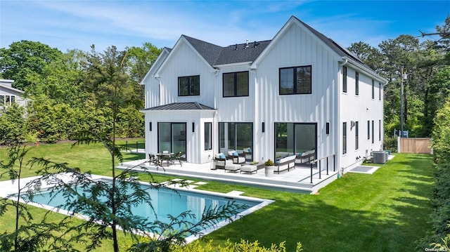 back of property featuring a patio, a standing seam roof, an outdoor living space, a yard, and metal roof