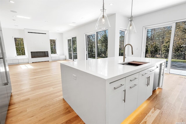 kitchen featuring a glass covered fireplace, plenty of natural light, and a sink