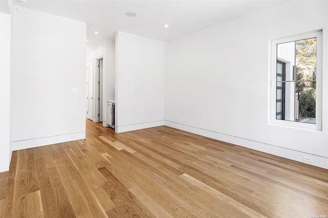 spare room with recessed lighting, baseboards, and light wood finished floors