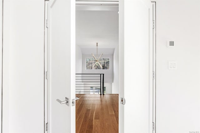 hall featuring an upstairs landing and wood finished floors