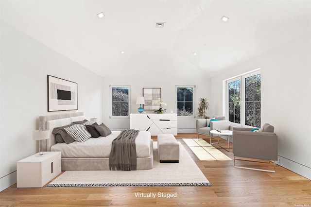 bedroom featuring wood finished floors, visible vents, and high vaulted ceiling