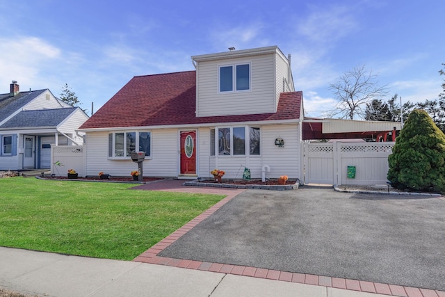 view of front of home featuring a gate, roof with shingles, a front yard, and fence